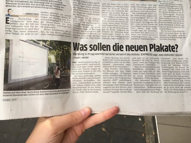 German newspaper article with a photo of one of our billboards and the headline "What are these billboards about?"